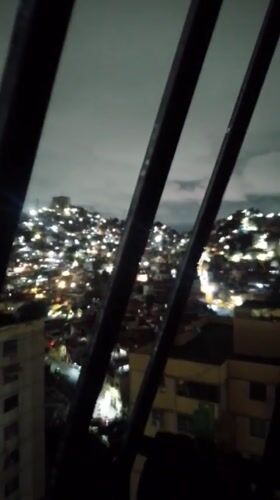 Nighttime cityscape captured across Caracas under cloudy skies