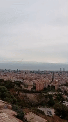 Panoramic Barcelona cityscape captured from elevated viewpoint under overcast skies