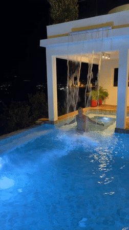 Man enjoys nighttime swim in illuminated Thailand pool