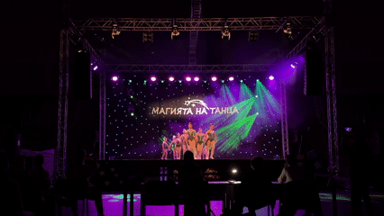 Dance performance featuring traditional costumes and Cyrillic stage backdrop