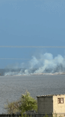 Vegetation fire burns near water in Kamyshin, Russia