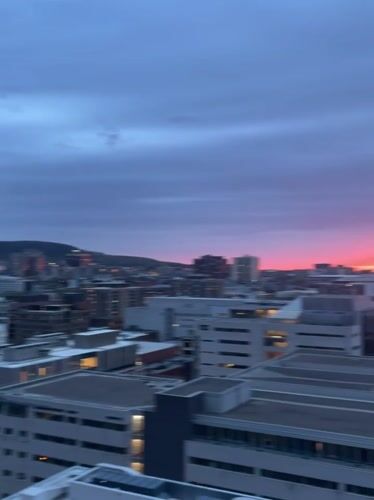Colorful sunset observed across Montreal skyline from elevated viewpoints