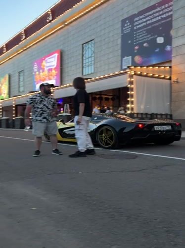 Exotic car meet outside an ornate Moscow venue at dusk