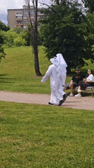 Two people in white robes walk park path in Sofia