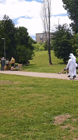 Two people in white robes walk park path in Sofia