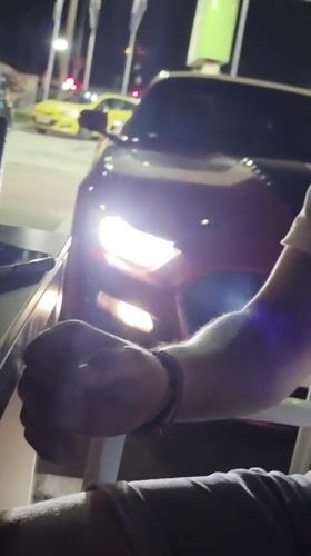 Red racing-striped car parked at Varna gas station after dark