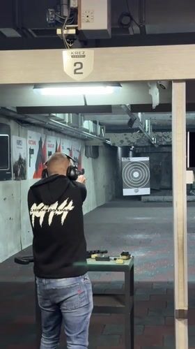 Man practices target shooting at indoor range in Bulgaria