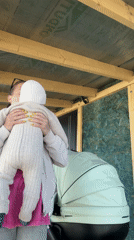Woman holds baby outdoors in Razdol'e, Russia