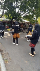 Marching band parades through Malang in traditional-style uniforms
