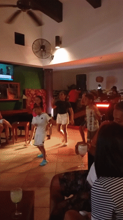 Children and women dance at Venezuela beach venue