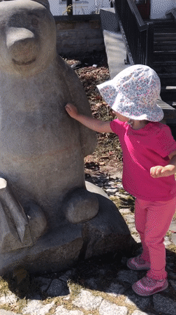 Toddler plays on animal sculptures in Wisła, Poland