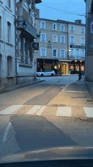 Brief drive through Saint-Galmier captures flags, church, street scenes