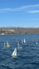 RC sailboats sail near Opatija boatyard under clear skies