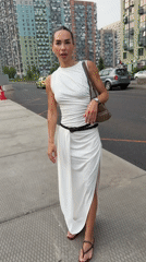Woman in white dress navigates city streets, boards bus