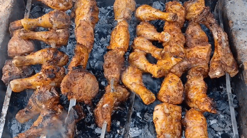 Chicken and vegetables grilling over hot coals