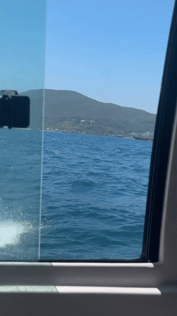 Boat passenger films window view in Nha Trang waters