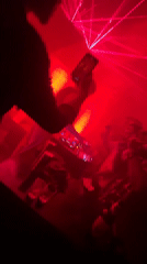 DJ performs at Chennai nightclub with red lasers, dancing crowd