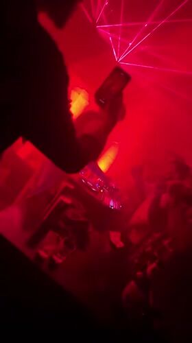 DJ performs at Chennai nightclub with red lasers, dancing crowd