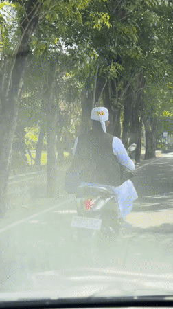 Traditional-dressed rider spotted on scooter in Kuta, Indonesia