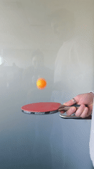 Person bounces ping-pong ball on paddle in Riga