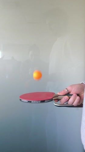 Person bounces ping-pong ball on paddle in Riga