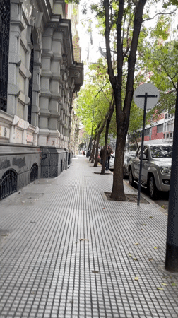 Buenos Aires sidewalk scene captured showing ornate building, trees