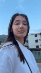 Young woman walks through Sutomore streets on windy afternoon