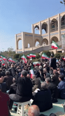Flag-waving crowd gathers for outdoor demonstration in Tehran