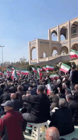 Flag-waving crowd gathers for outdoor demonstration in Tehran
