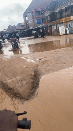 Motorcycles wade through waist-deep flooding in Ihiagwa, Nigeria