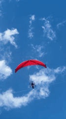 Paraglider spotted over calm Nea Vrasna beach on clear day