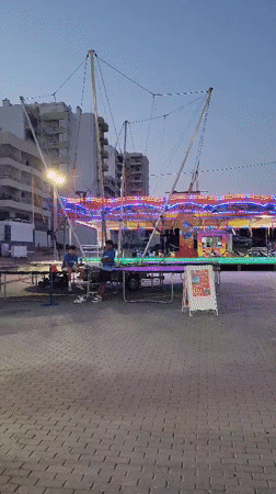 Summer fairground evening in Quarteira — rides, food stalls, lights