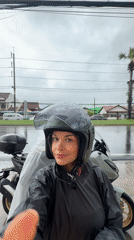 Motorcyclists weather rainstorm in Ko Kaeo, Thailand