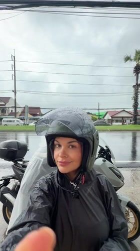 Motorcyclists weather rainstorm in Ko Kaeo, Thailand