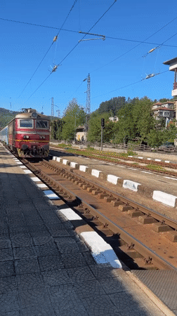 Red train arrives at Tryavna station on sunny morning