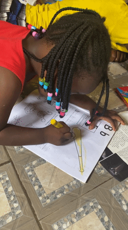 Child practices letters and coloring at home in Nigeria