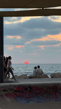 Tel Aviv beach at golden hour, waves and dusk sky