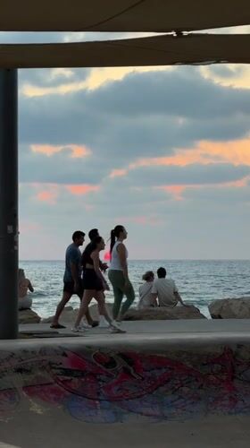 Tel Aviv beach at golden hour, waves and dusk sky