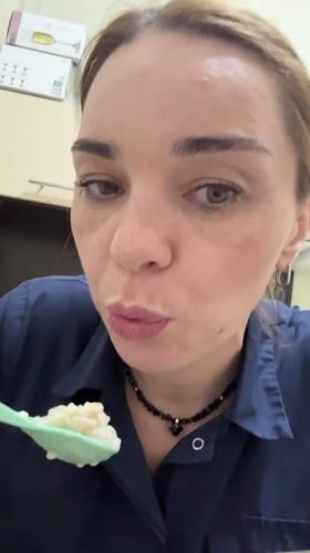 Woman eating with green spoon recorded in Murino, Russia