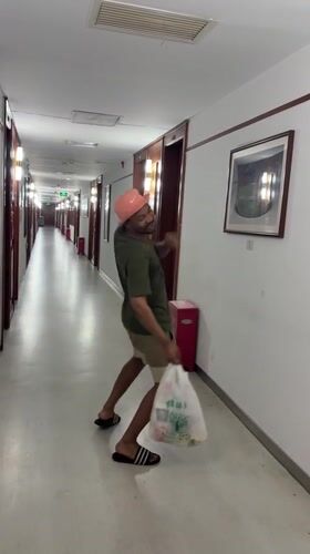 Strolling a hotel hallway in Daxing, bag in hand