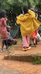 Kids huddle around something on a dirt path in Jos