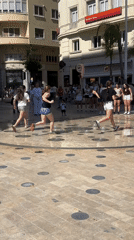 Children play in fountain jets at Alicante square