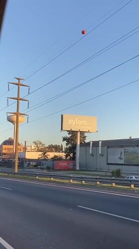 Vehicle drives through industrial Don Torcuato under clear skies