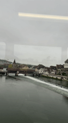 Train passenger views Bremgarten's river and covered bridge