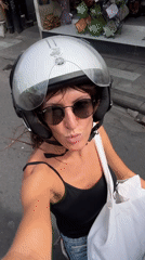 Scooter rider cruises sunny Kuta streets, selfie in hand