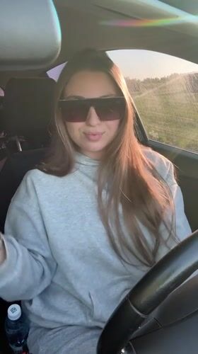 Woman removes sunglasses, smiles at camera in Omsk
