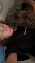 Woman plays with small curly dog in Krasnoyarsk