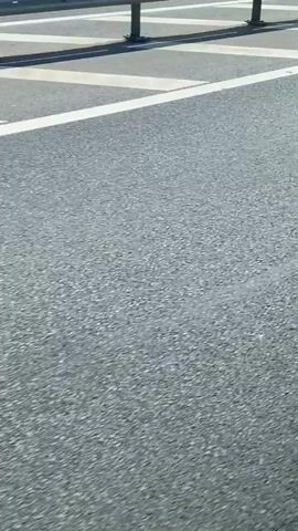 The video shows a view of a highway guardrail and the asphalt road surface as the camera moves along the highway. The guardrail is made of metal and has a white line running along its base. The asphalt is gray and shows some cracks and wear. The video appears to be taken from inside a moving vehicle.