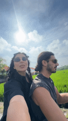 Couple films selfies while scootering through Indonesian rice fields