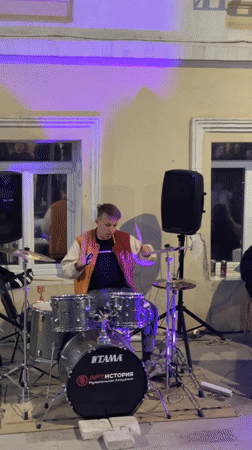 Street drummer performs among shipping container shops in Ufa